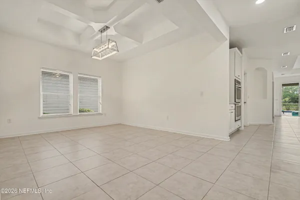 a view of an empty room with furniture and windows