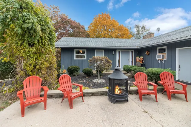 a backyard of a house with fire pit and outdoor seating
