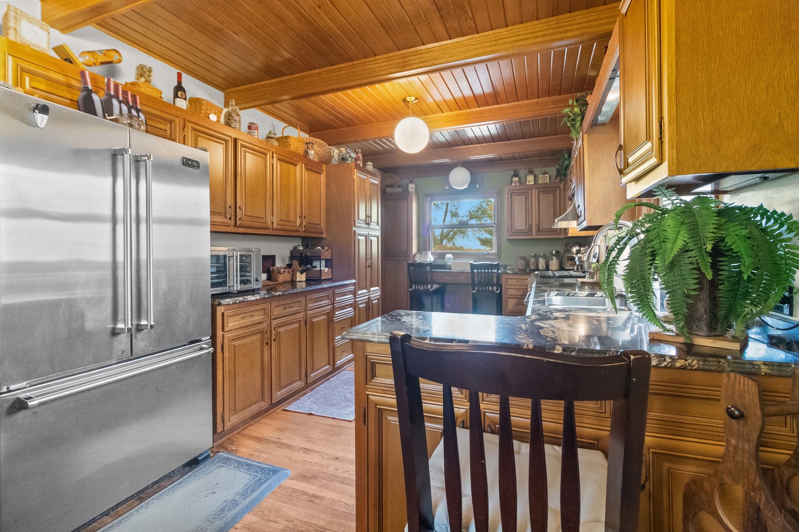 7822 North Pillow Hill Road Spring Grove, IL 60081 - Photo 21 of 34 a kitchen with stainless steel appliances granite countertop a refrigerator and wooden cabinets