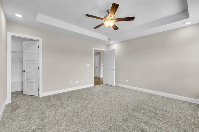 an empty room with ceiling fan and window