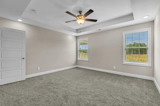 an empty room with window and ceiling fan