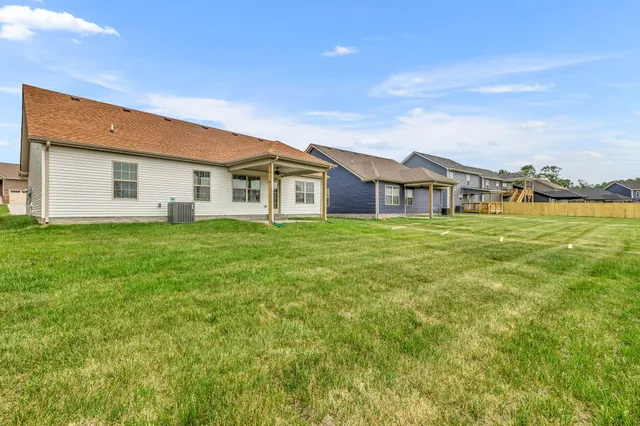 a view of a house with a big yard and large trees