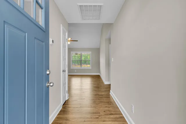 a view of a hallway with wooden floor