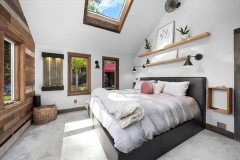 a spacious bedroom with a bed couch and a large window