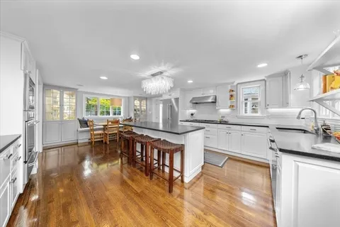 a kitchen with white cabinets and sink