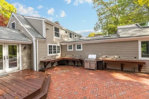 a backyard of a house with barbeque oven and outdoor seating