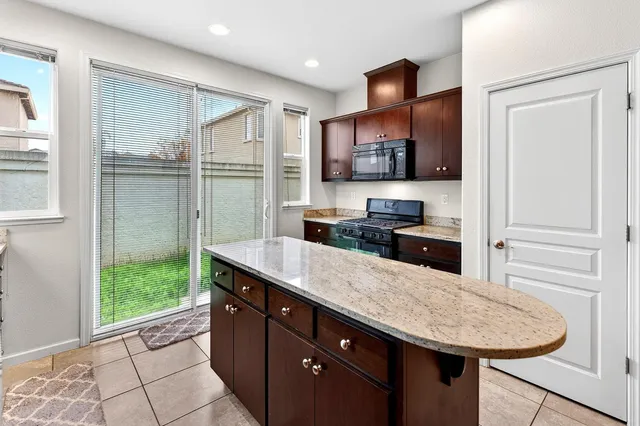 a kitchen with stainless steel appliances granite countertop a sink and a stove