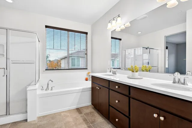a bath room with a sink vanity tub and a mirror