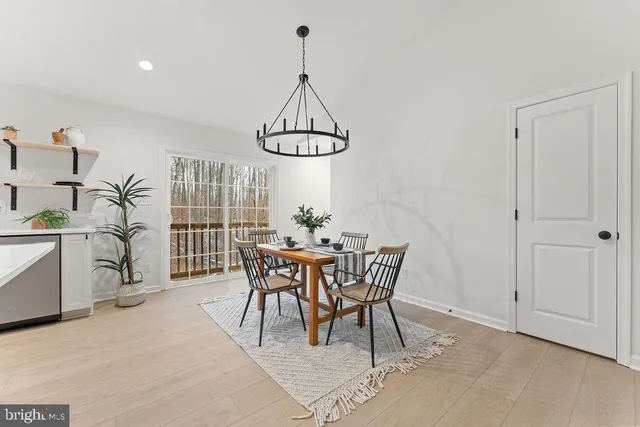 a large white kitchen with lots of counter space a sink and stainless steel appliances