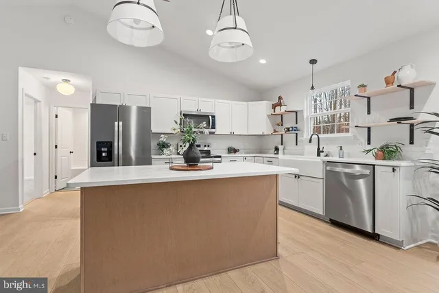 a kitchen with white cabinets and stainless steel appliances