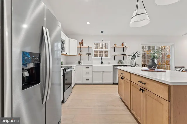 a kitchen with stainless steel appliances a sink stove refrigerator and a window