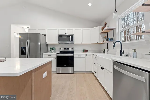 a view of a dining room with furniture a kitchen and chandelier