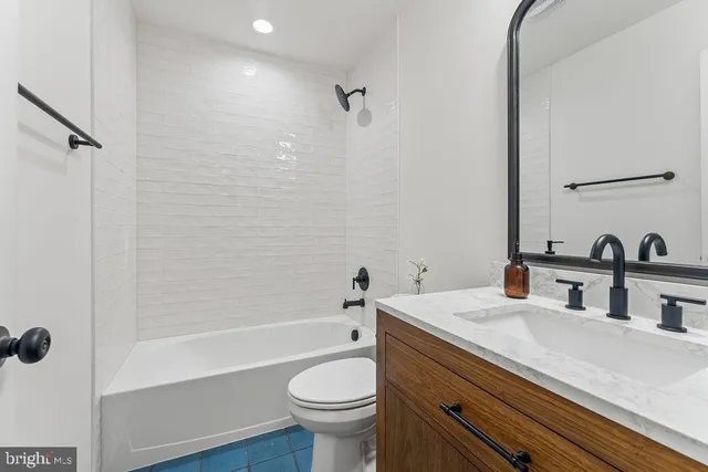 a bathroom with a sink a toilet a mirror and shower