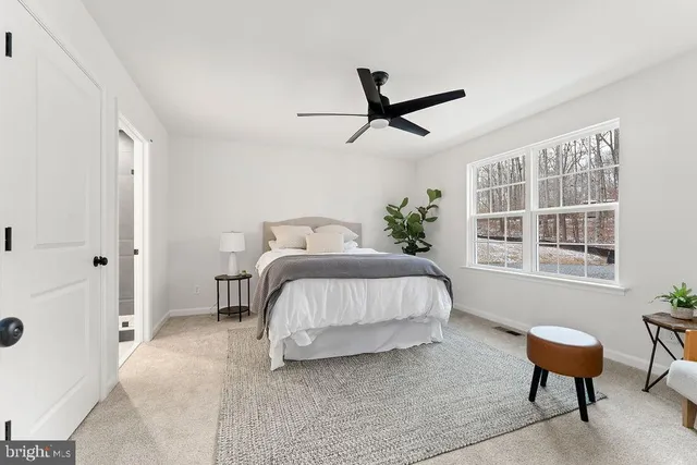a bed sitting in a bedroom next to a window