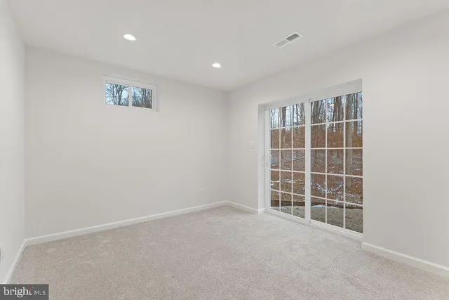 a front view of a house with a garden and trees