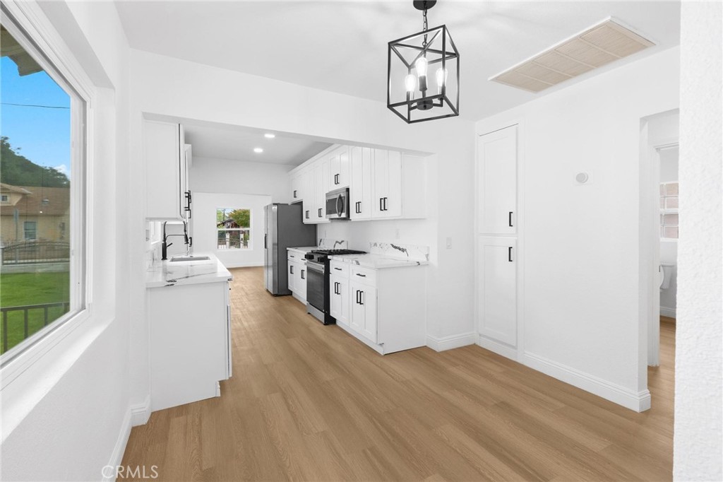 3882 Taft Street Riverside, CA 92503 - Photo 13 of 37 a kitchen with stainless steel appliances a white stove top oven and a chandelier