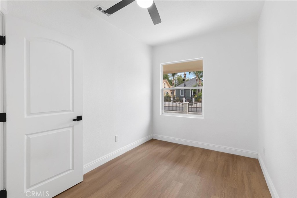 3882 Taft Street Riverside, CA 92503 - Photo 19 of 37 an empty room with wooden floor cabinet and windows