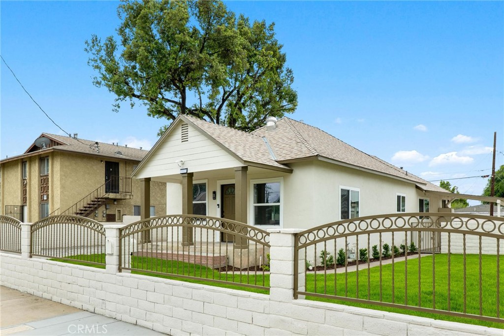3882 Taft Street Riverside, CA 92503 - Photo 4 of 37 a view of a white house with large windows and a small yard