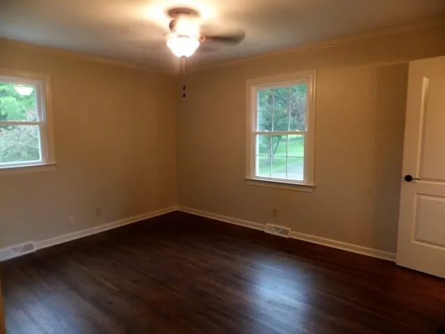 a view of a room with wooden floor and windows