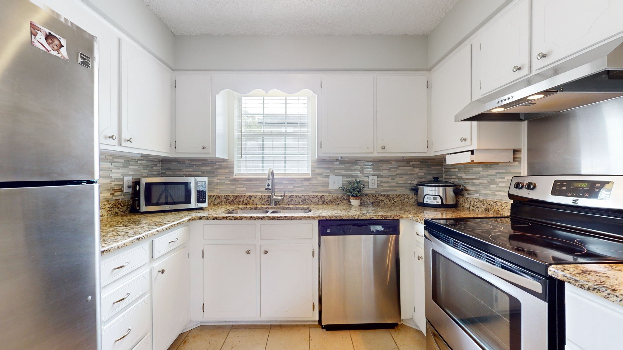 3229 New Towne Road Antioch, TN 37013 - Photo 6 of 35 a kitchen with granite countertop a stove sink and cabinets