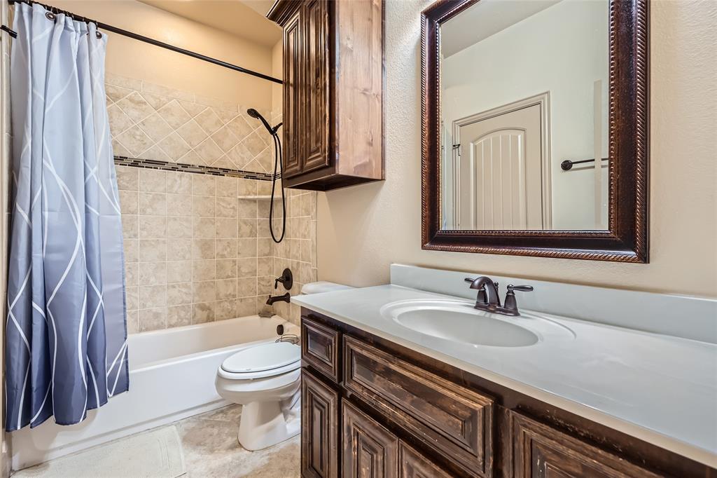 813 Goose Court Forney, TX 75126 - Photo 20 of 28 a bathroom with a granite countertop sink toilet and shower