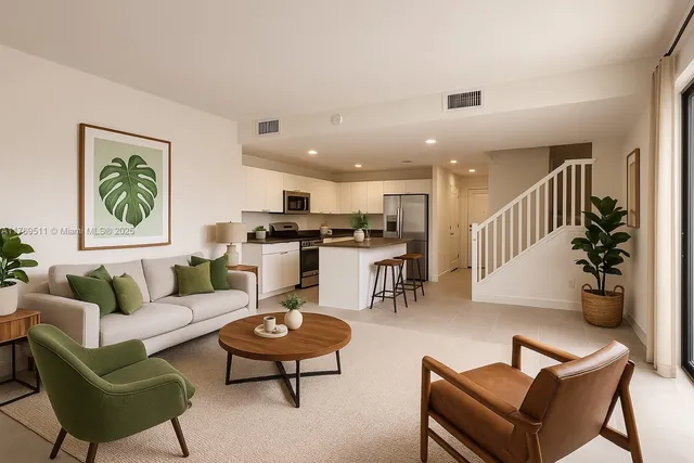 a living room with furniture kitchen view and a wooden floor