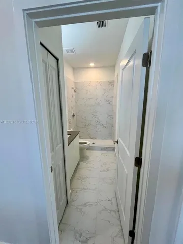 a bathroom with a glass door shower and toilet