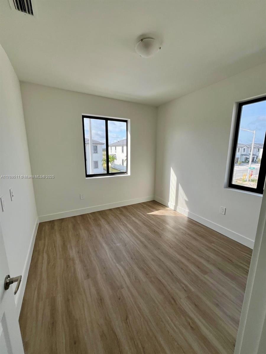 18995 Southwest 345th Terrace Homestead, FL 33034 - Photo 4 of 21 a view of empty room with wooden floor and fan