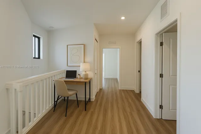 a view of a room with wooden floor windows a ceiling fan and windows