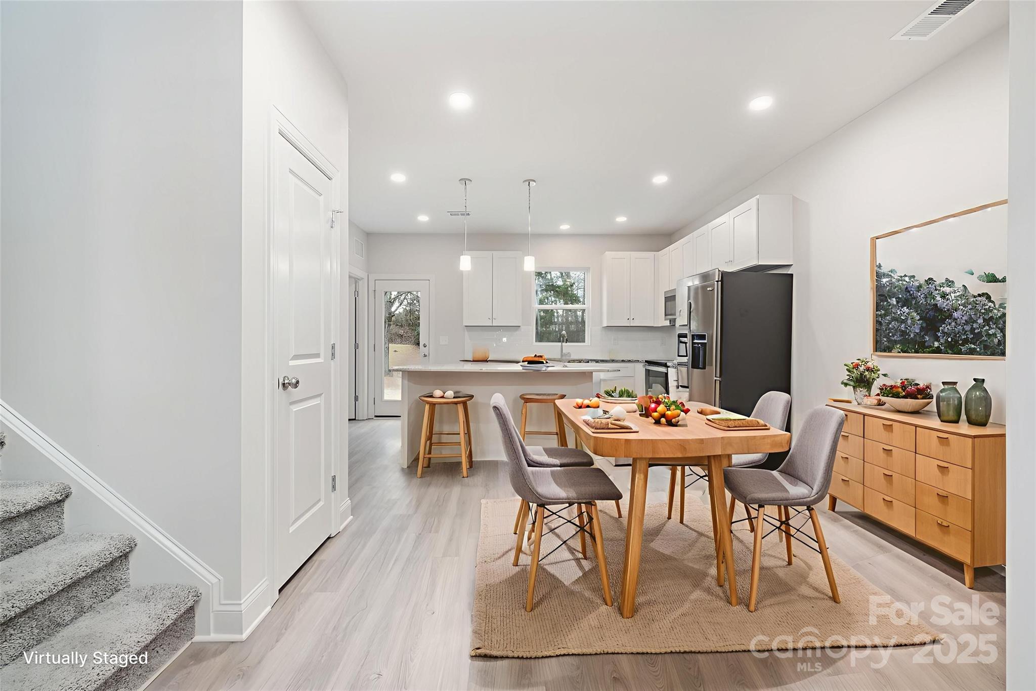 19901 Burton Lane Cornelius, NC 28031 - Photo 4 of 28 a dining room with stainless steel appliances kitchen island granite countertop a dining table chairs and a refrigerator