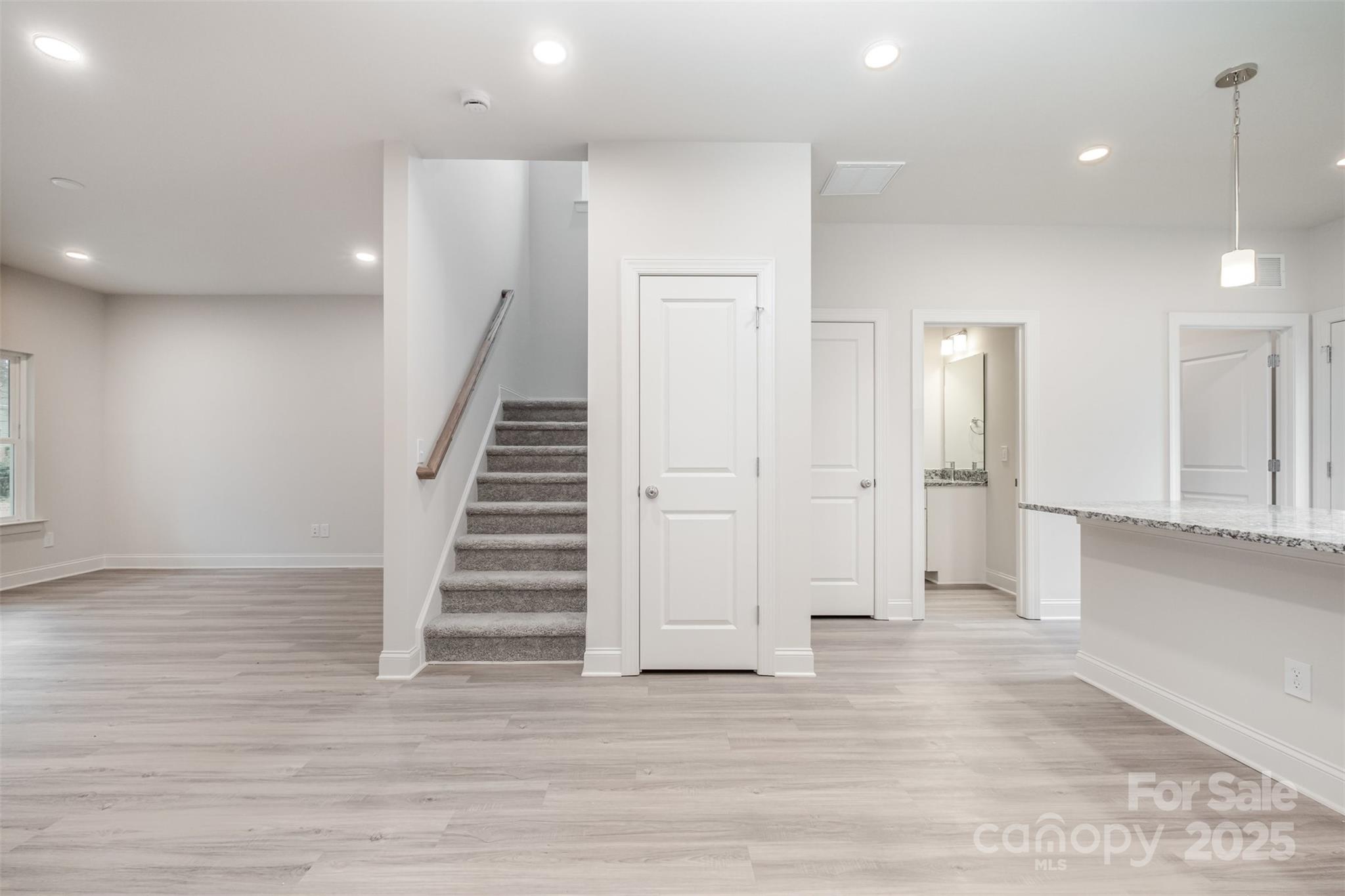 19901 Burton Lane Cornelius, NC 28031 - Photo 6 of 28 a view of a hallway with wooden floor and staircase