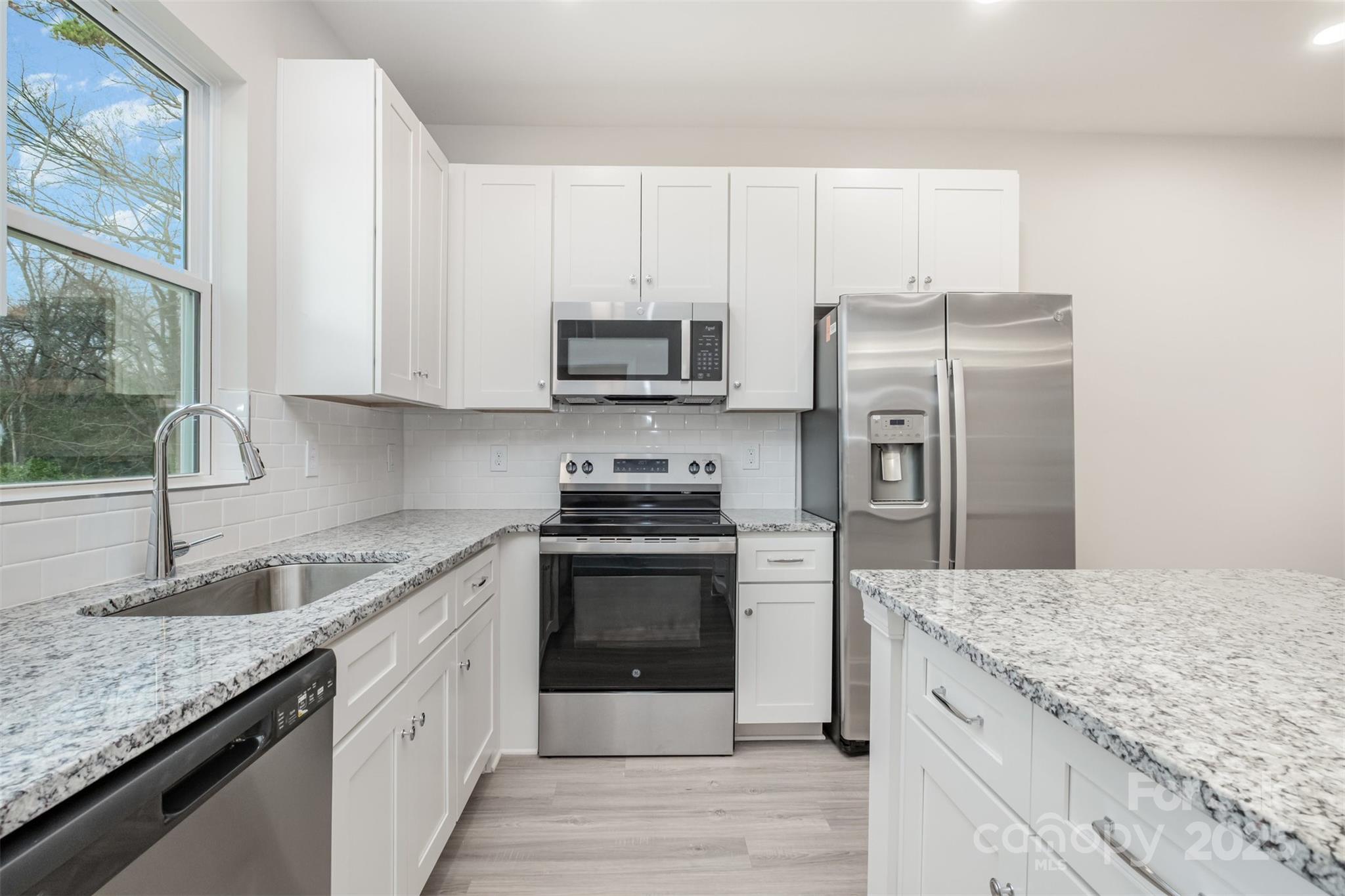19901 Burton Lane Cornelius, NC 28031 - Photo 8 of 28 a kitchen with stainless steel appliances granite countertop a sink stove and refrigerator