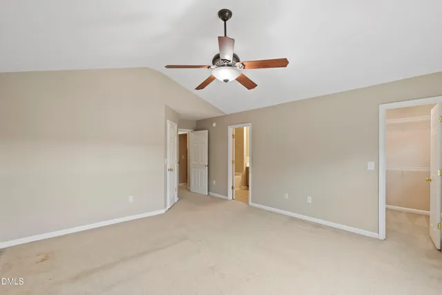 an empty room with chandelier fan