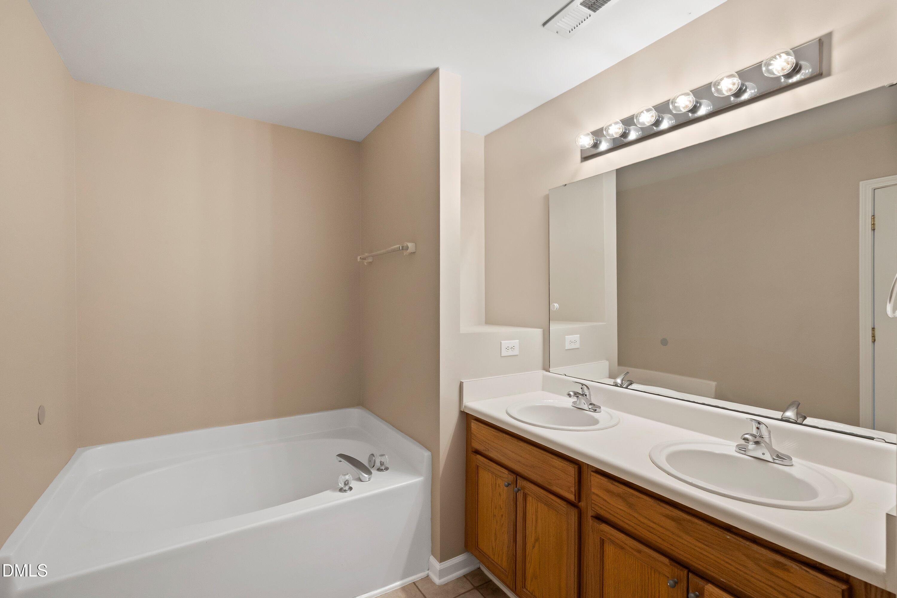 11 Kinglet Court Durham, NC 27713 - Photo 18 of 32 a bathroom with a tub a sink and mirror