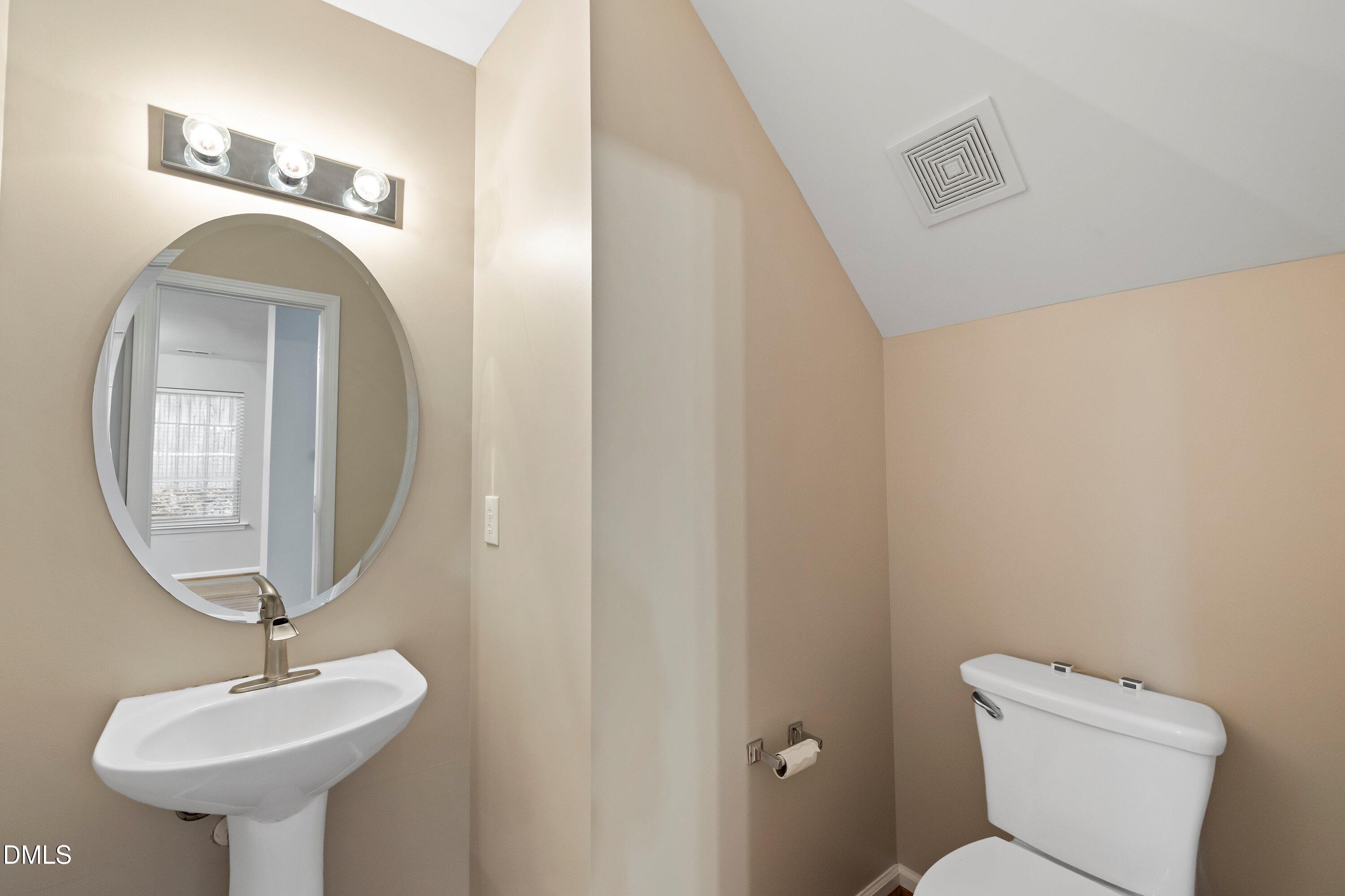 11 Kinglet Court Durham, NC 27713 - Photo 28 of 32 a bathroom with a toilet sink and mirror