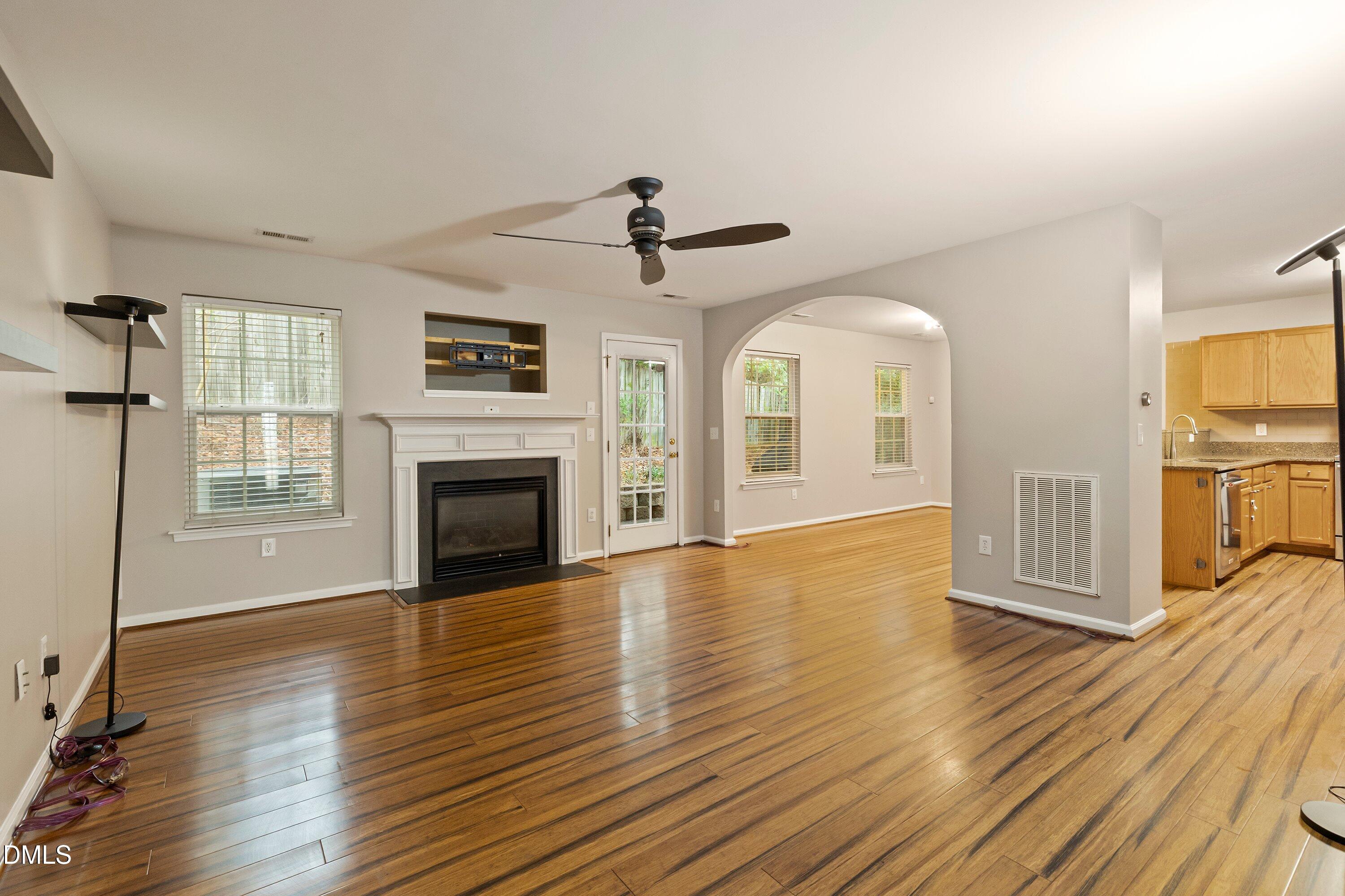 11 Kinglet Court Durham, NC 27713 - Photo 5 of 32 an empty room with wooden floor fireplace and windows