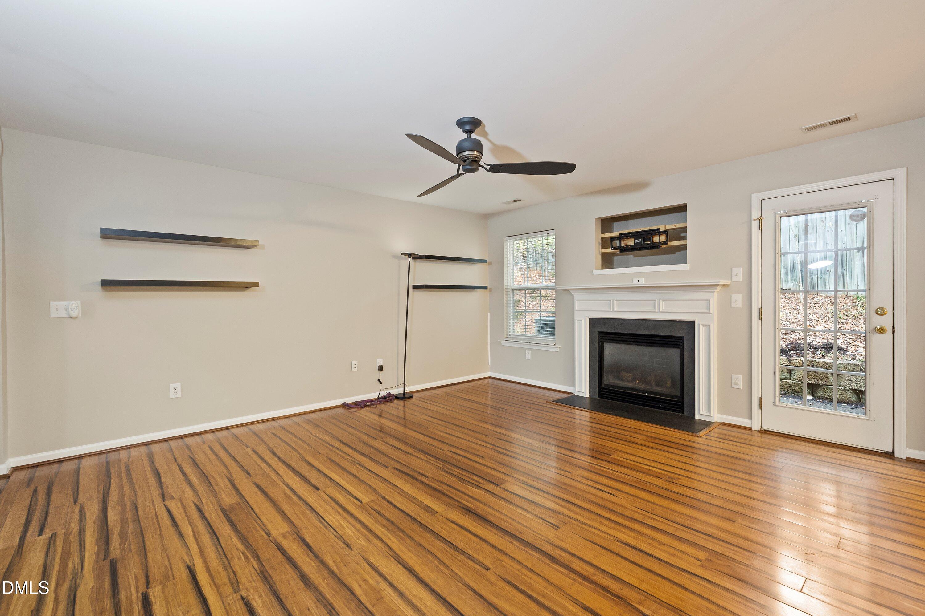 11 Kinglet Court Durham, NC 27713 - Photo 6 of 32 a view of empty room with wooden floor and fireplace