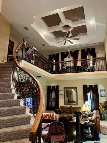 a living room with lots of furniture and a ceiling fan