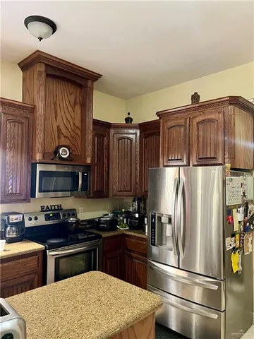 a kitchen with stainless steel appliances granite countertop a refrigerator and a stove