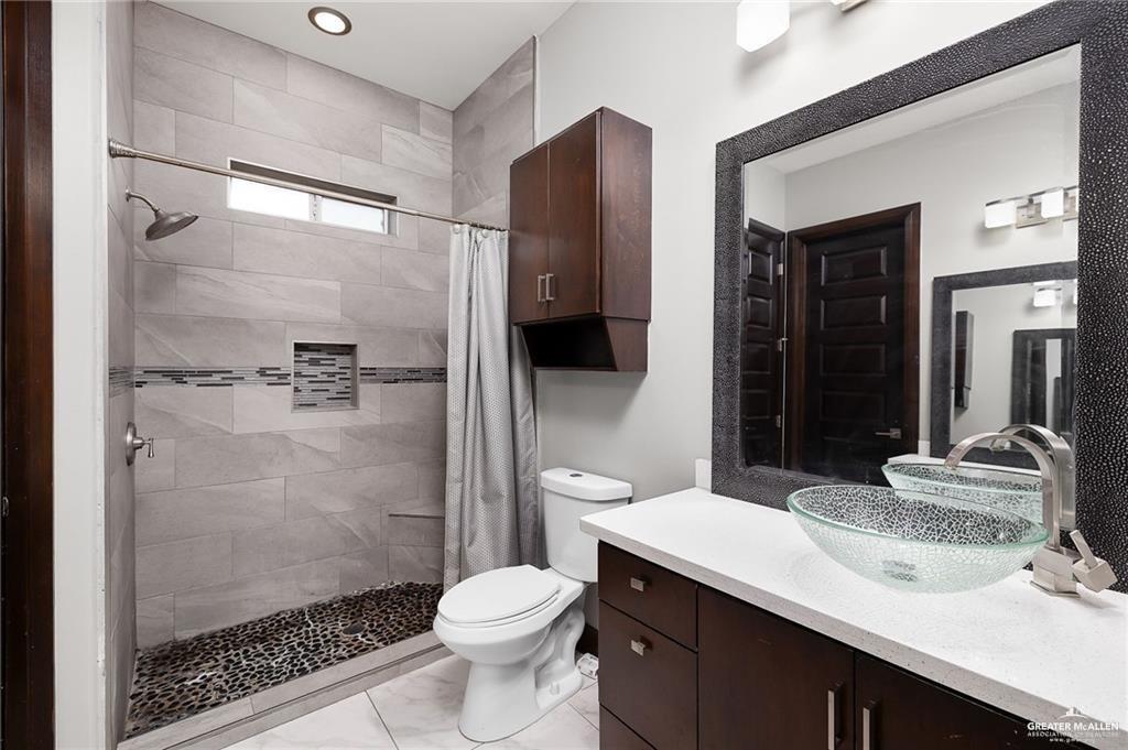 1509 Leandro Street Mission, TX 78574 - Photo 7 of 11 a bathroom with a sink a toilet and shower