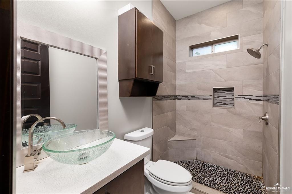 1509 Leandro Street Mission, TX 78574 - Photo 9 of 11 a bathroom with a sink a toilet and shower