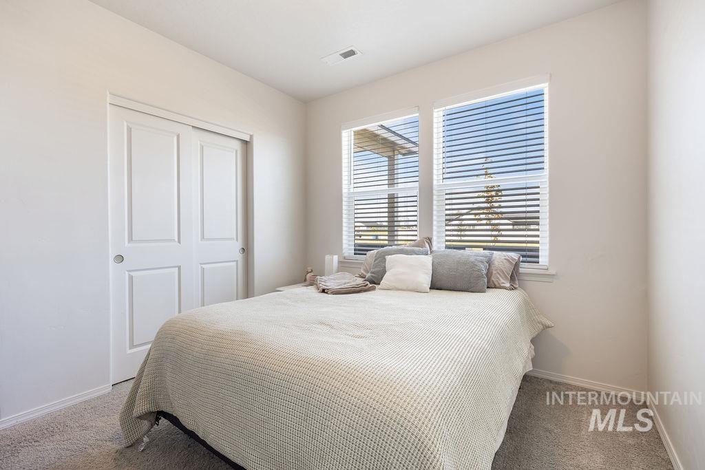 4601 Great Fls Avenue Caldwell, ID 83607 - Photo 16 of 29 Bedroom featuring neutral-toned walls, two panel sliding closet doors, two large windows with blinds, and carpeting
