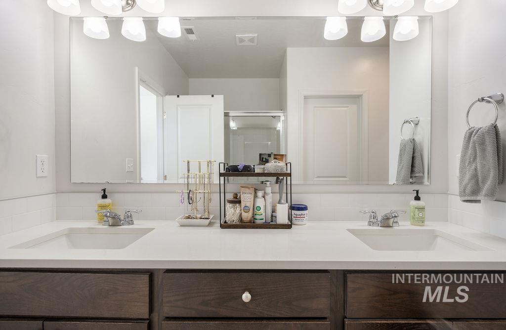 4601 Great Fls Avenue Caldwell, ID 83607 - Photo 25 of 29 Double vanity featuring white integrated sinks, chrome faucets, and a large wall-mounted mirror