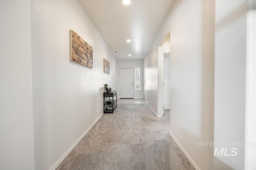 4601 Great Fls Avenue Caldwell, ID 83607 - Photo 27 of 29 Entryway featuring light gray carpeting, white walls, recessed ceiling lighting, a white paneled door, and a vertical window