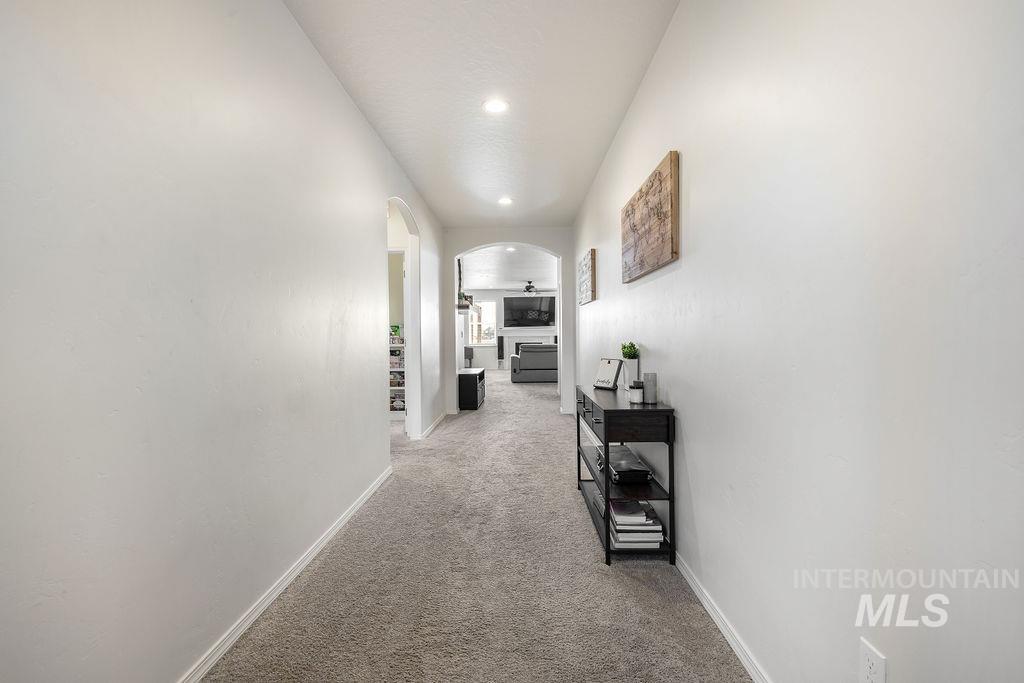 4601 Great Fls Avenue Caldwell, ID 83607 - Photo 4 of 29 Hallway with neutral tone walls and carpeting, featuring recessed lighting and arched doorways