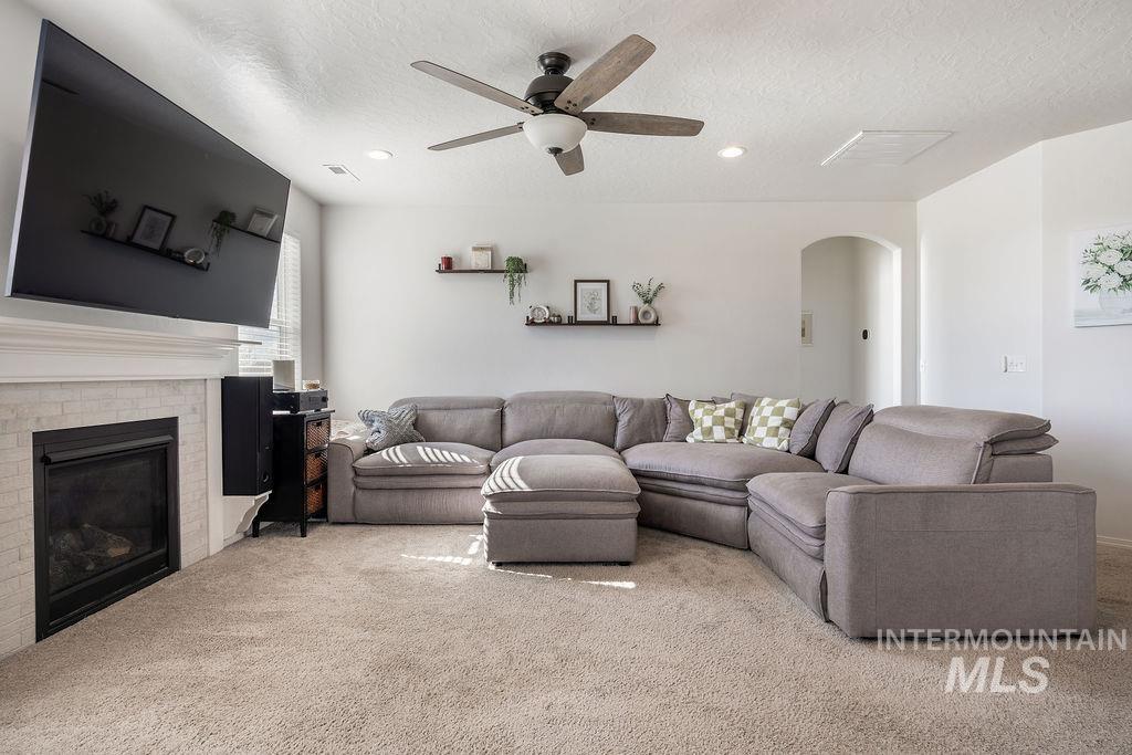 4601 Great Fls Avenue Caldwell, ID 83607 - Photo 6 of 29 Living area featuring a fireplace with a light-toned tile surround and mantle, recessed lighting, and a ceiling fan