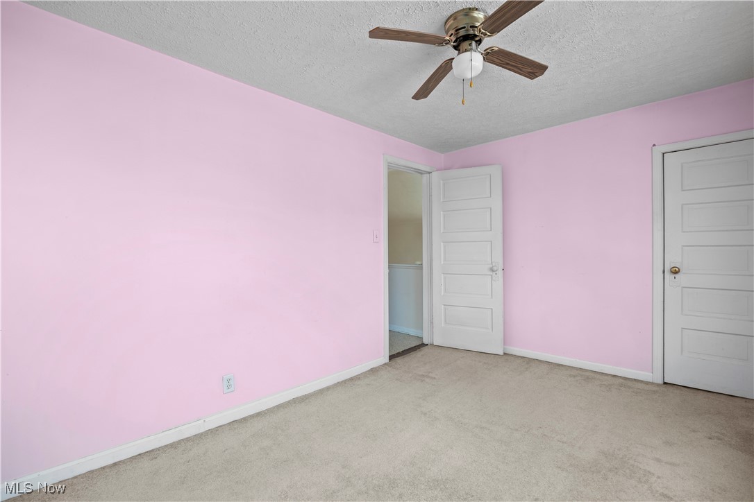 6927 North Wildacre Road Curtice, OH 43412 - Photo 34 of 44 Unfurnished bedroom with carpet, a textured ceiling, and ceiling fan