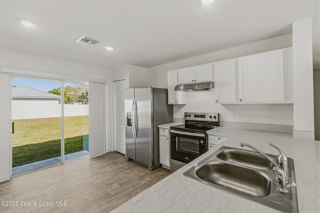 a kitchen that has a sink cabinets and a stove