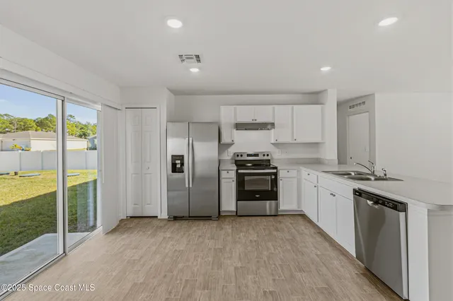 a kitchen with stainless steel appliances a refrigerator sink and stove