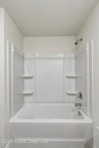 an empty room with window and mirror